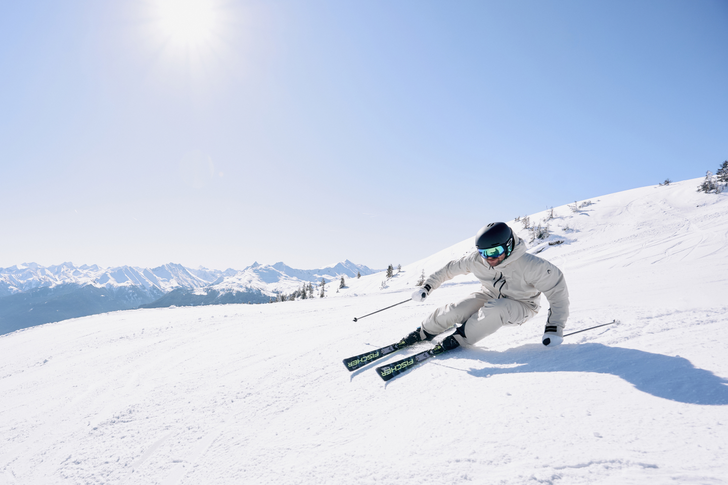 Skifahrer, der an einem sonnigen Tag einen verschneiten Berghang hinunterfährt. Wintersport und Freizeitaktivitäten im Freien.